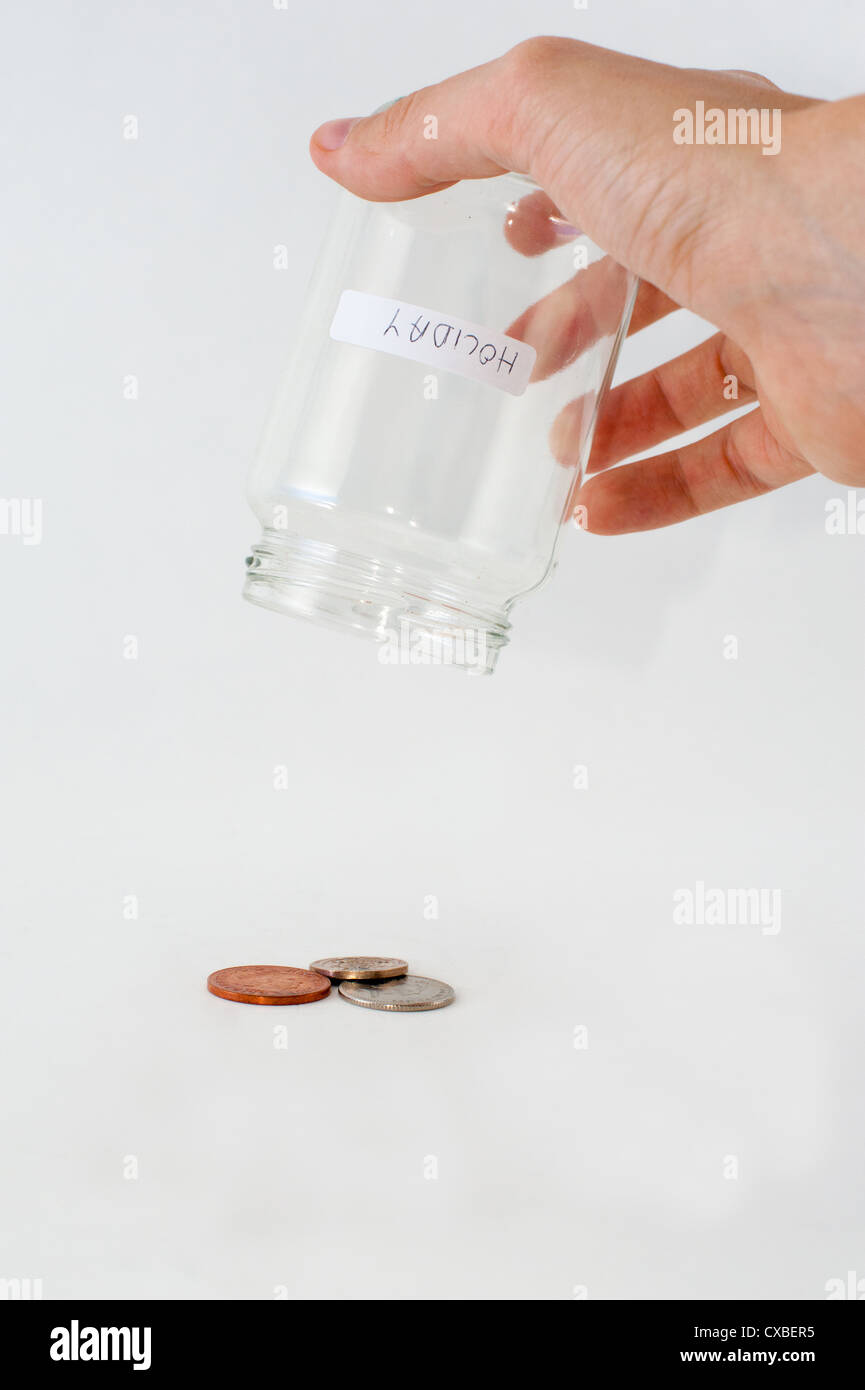 Money poured out of a glass jar with 'holiday' label Stock Photo