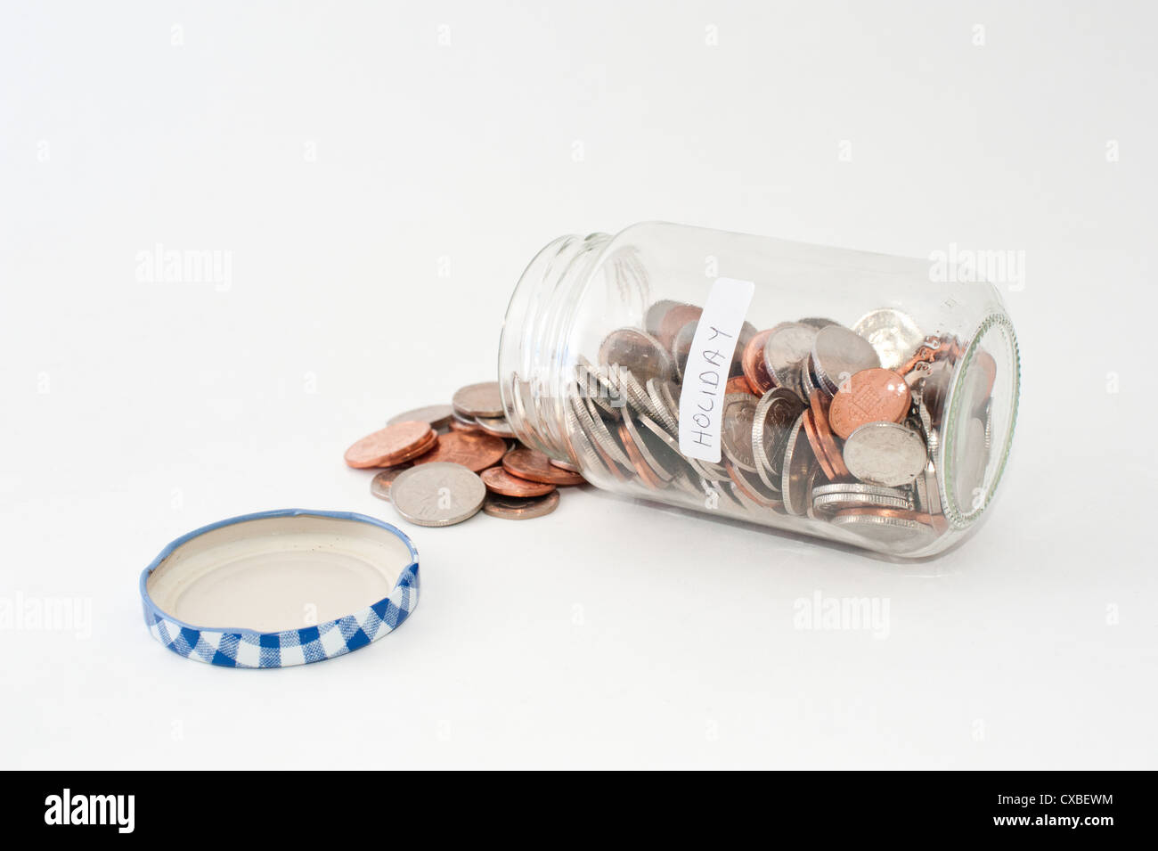 A glass jar of money with 'holiday' label. Stock Photo