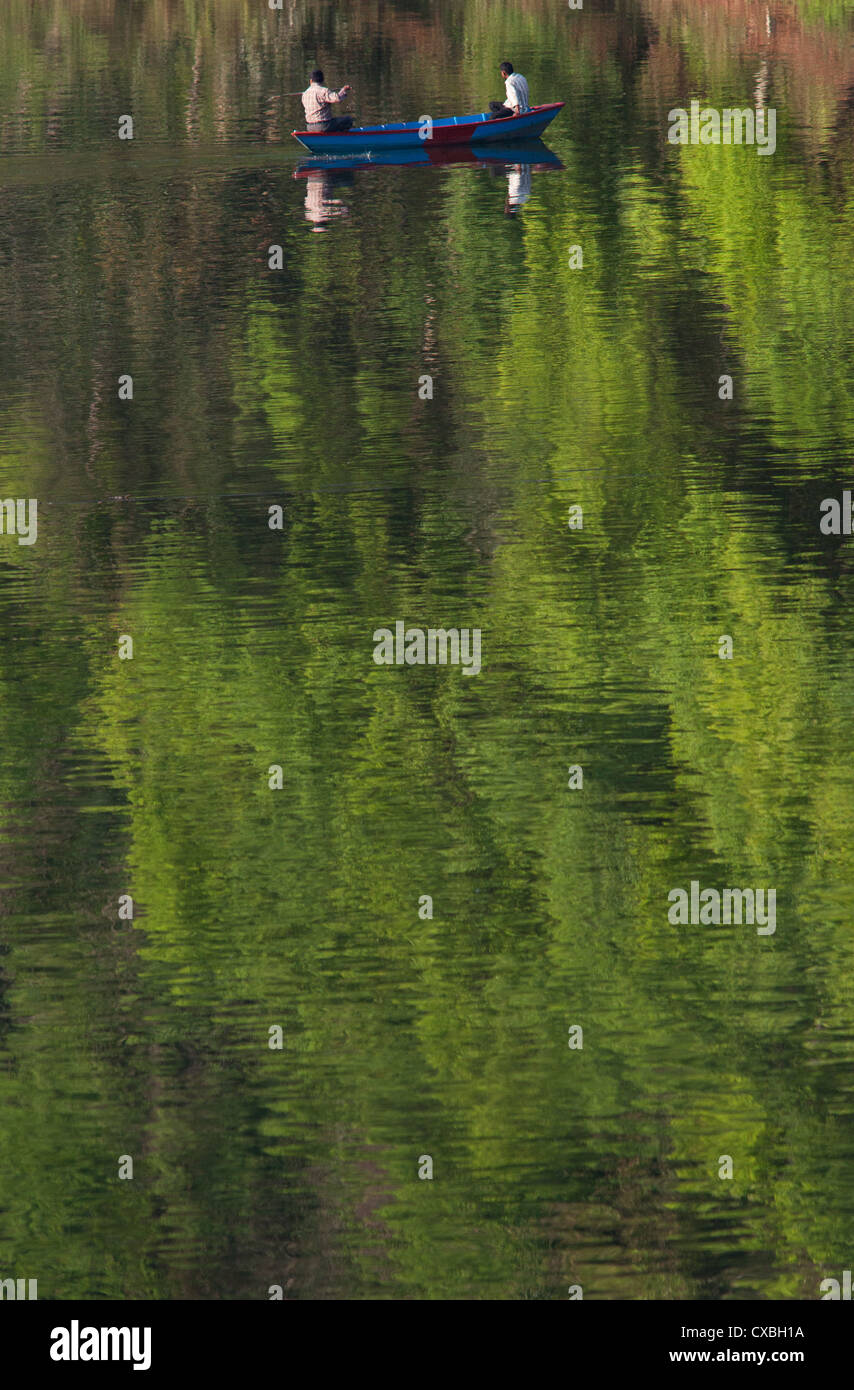Men in a rowing boat on Phewa Tal, a fresh water lake in Pokhara, Nepal Stock Photo