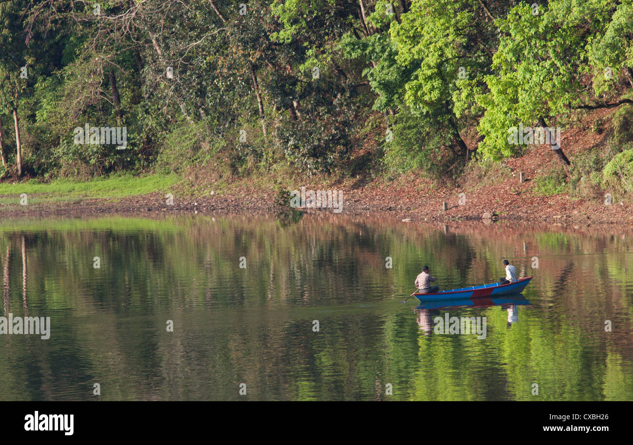 Men in a rowing boat on Phewa Tal, a fresh water lake in Pokhara, Nepal Stock Photo