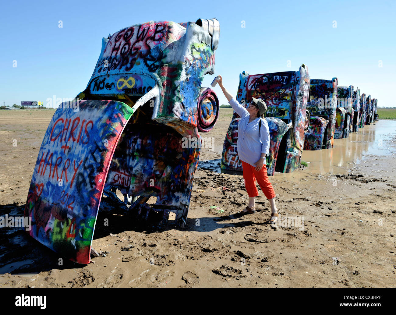 Cadillac Ranch, -art installation sculpture located on Route 66 in Amarillo Texas, with person spraying graffiti. Stock Photo