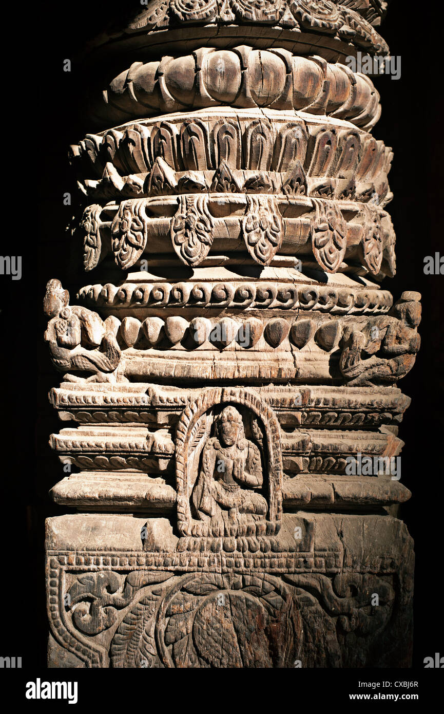 Hindu temple wooden column with Nepali Hindu God (Vishnu avatar) figure and floral ornament. Nepal, Kathmandu Stock Photo