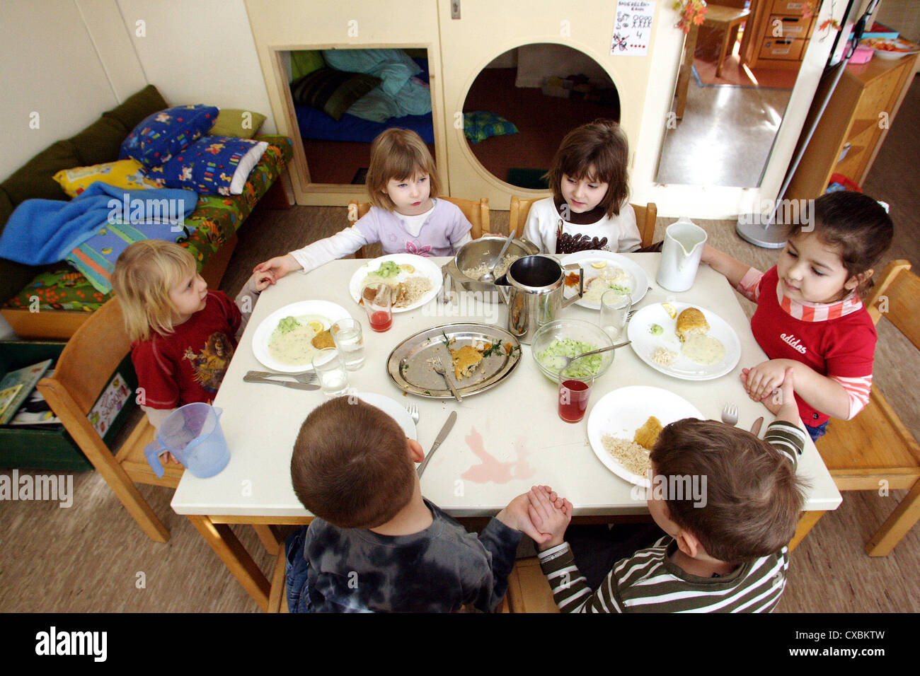 Berlin, children sit together at the table and eat lunch Stock Photo