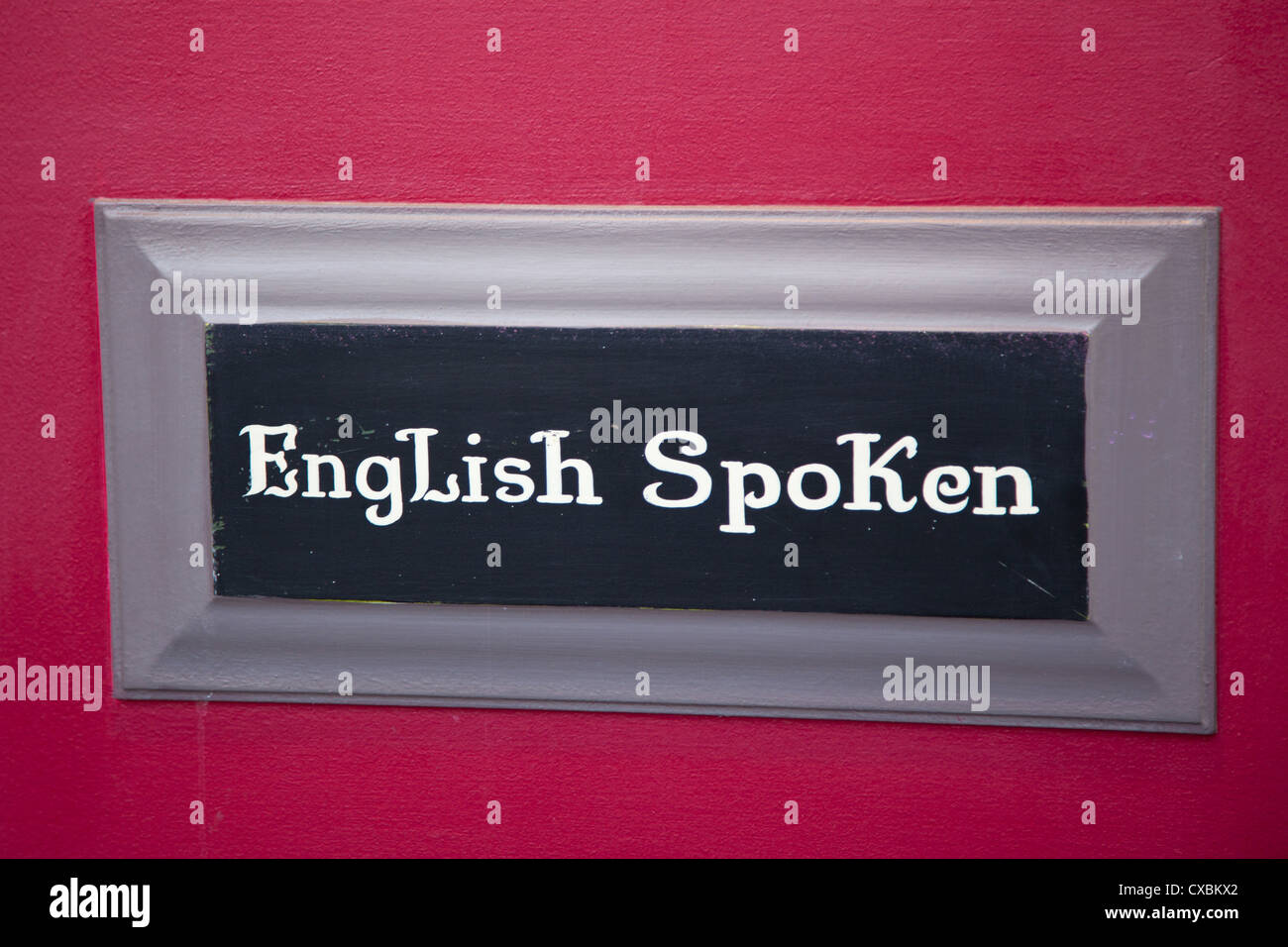 Sign outside a restaurant in Paris showing that english is spoken by the staff Stock Photo