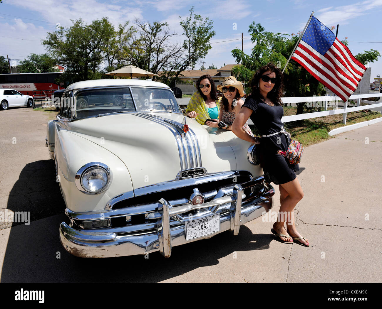 Young female travellers with a vintage American car, outside the legendary Blue Swallow Motel, Route 66, Tucumcari, New Mexico Stock Photo