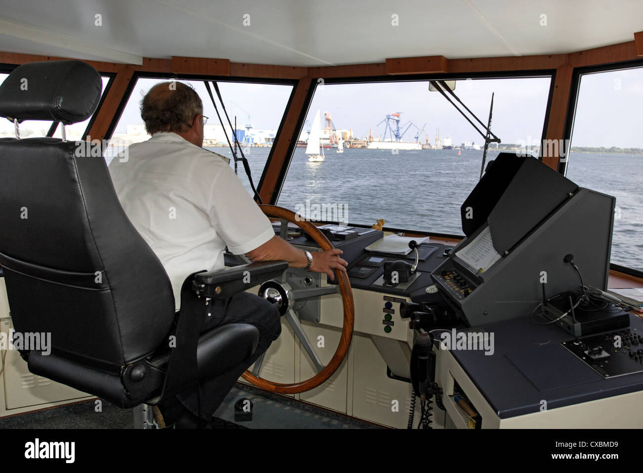Warnemuende, captain at the helm of his ship Stock Photo