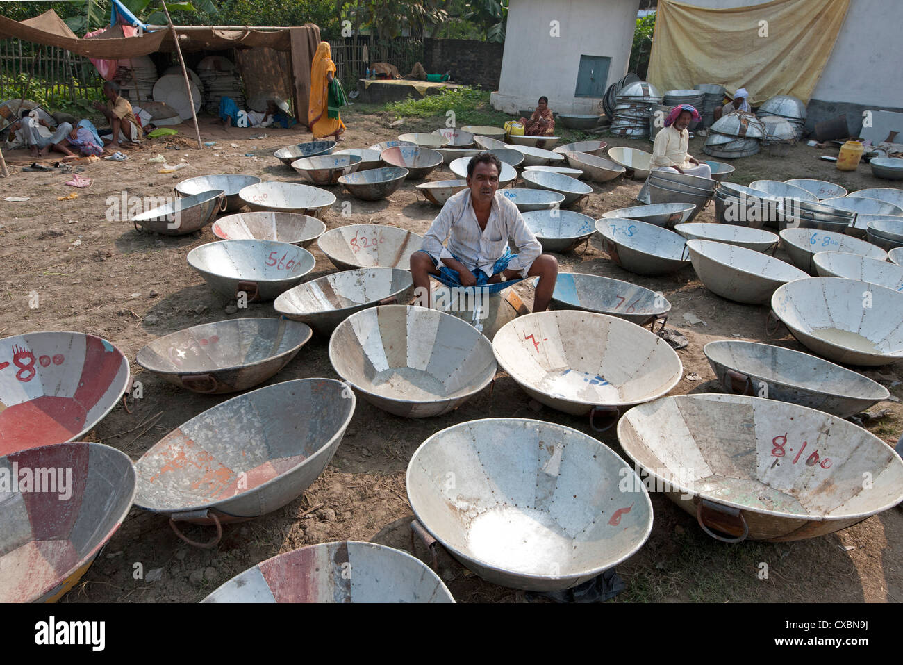 Man selling metal animal feed dishes at Sonepur Cattle Fair, Bihar