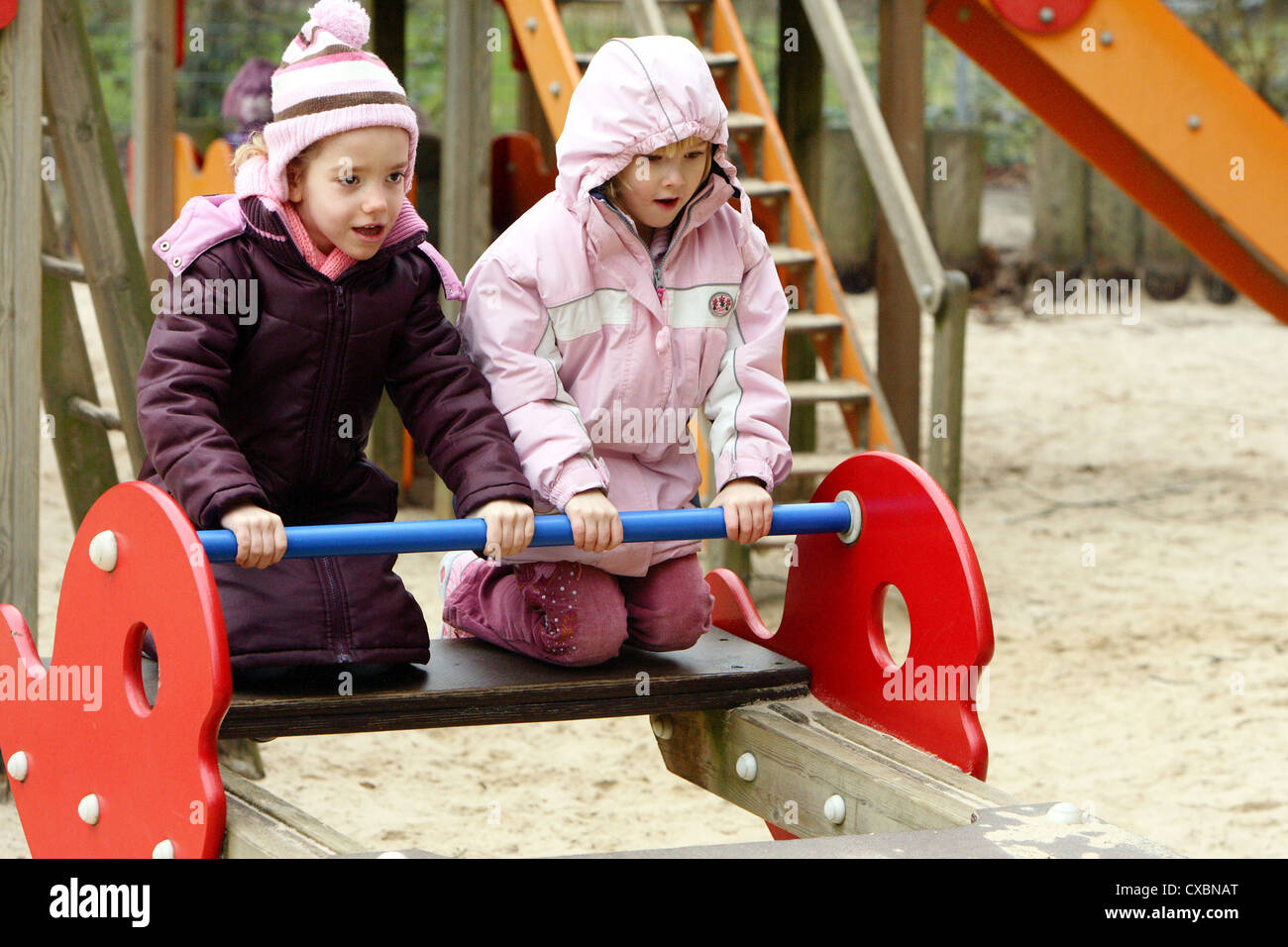 Berlin, girls bounce up a child on a playground seesaw Stock Photo