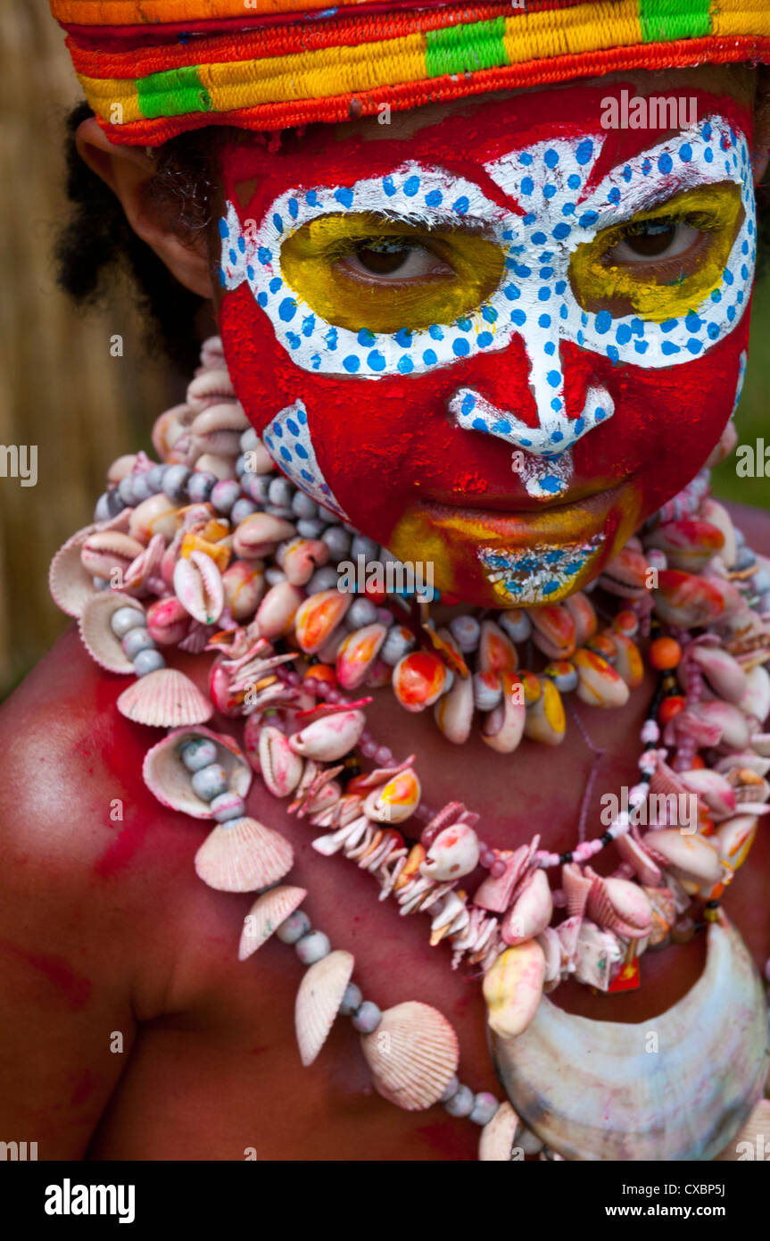Colourfully dressed and face painted local child celebrating the traditional Sing Sing in the Highlands of Papua New Guinea Stock Photo