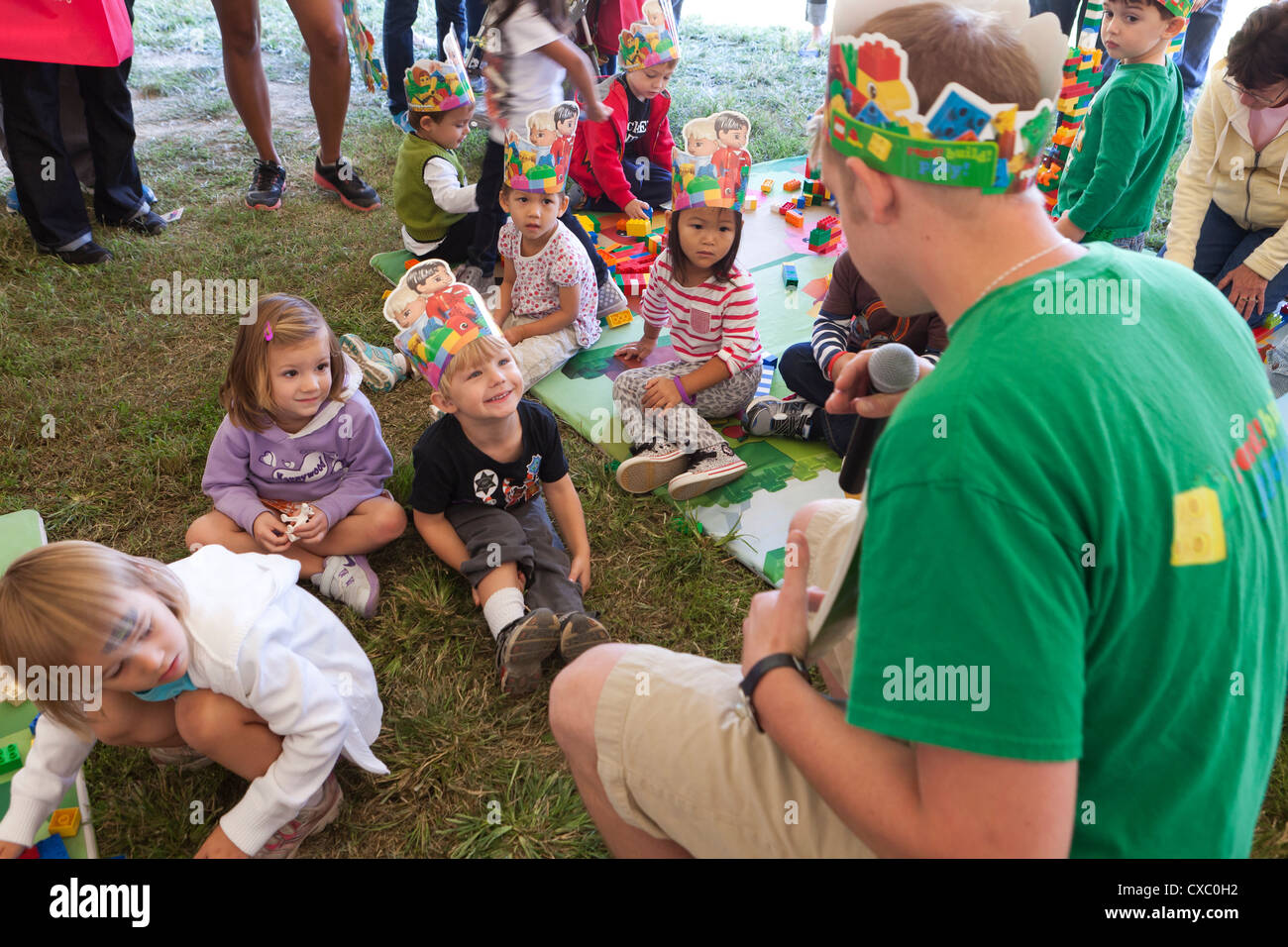 Children getting entertained by an adult at a party Stock Photo