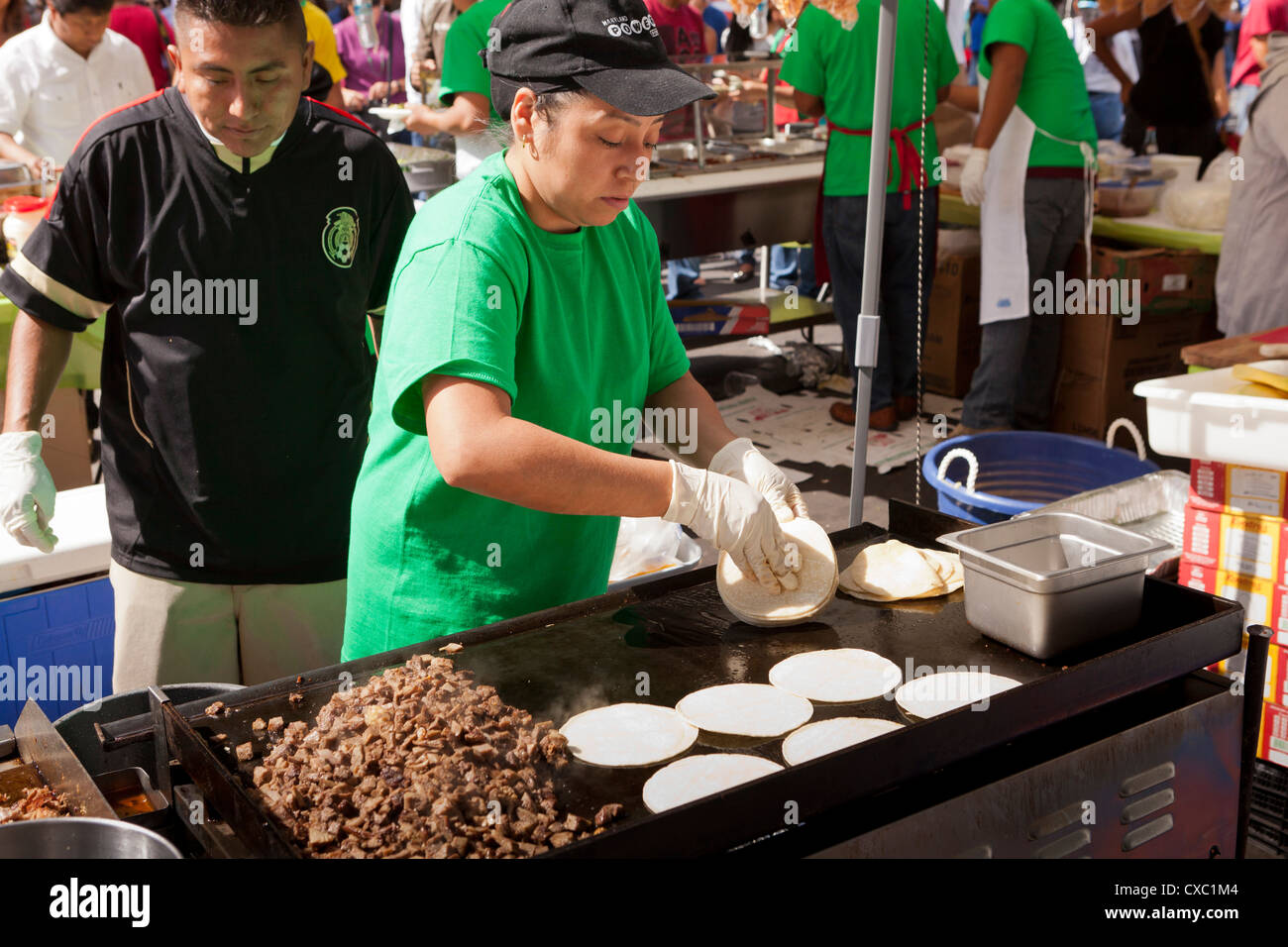 A woman grilling tortillas at an outdoor festival Stock Photo