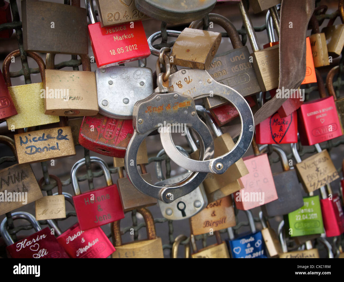 Padlocks and handcuffs symbolizing relationships on the Hohenzollernbrucke railway bridge in Cologne, Germany Stock Photo