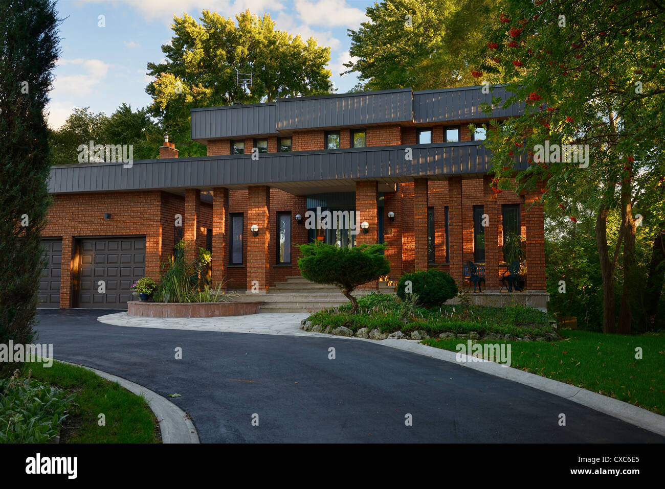 Front of a red brick house set in a ravine lot at sunset Toronto