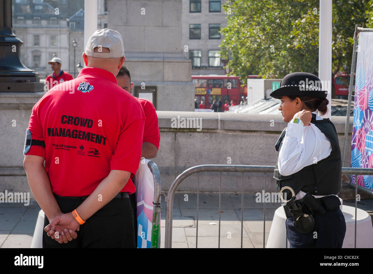London Trafalgar Square 2012 Paralympics screen area crowd management steward & Metropolitan Police policewoman handcuffs by barriers Stock Photo