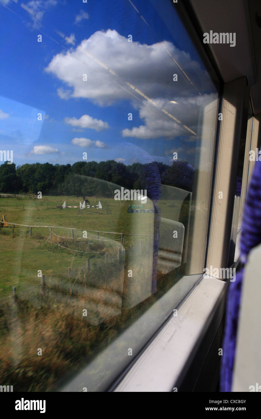 a view through a traveling train window taken as the train travels ...