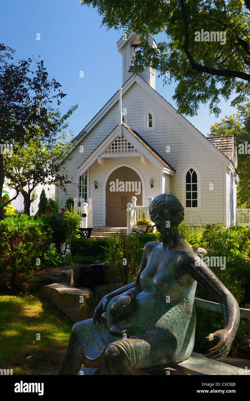 Sculpture of pregnant mother and child at white clapboard Chapel used for weddings in Kleinburg north of Toronto Ontario Canada Stock Photo