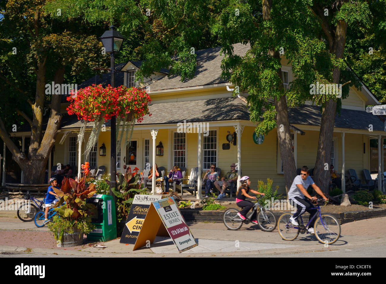 Tourists relaxing in a cafe on Islington Avenue in Kleinburg with children on bicycles north of Toronto Ontario Canada Stock Photo