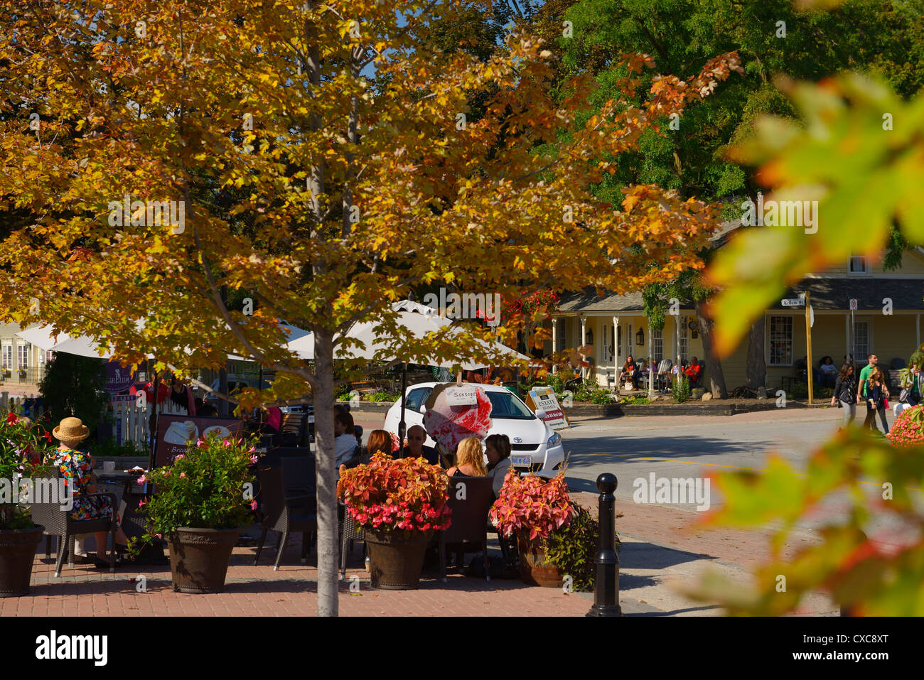 Early Fall in Kleinburg Ontario with changing leaves and tourists relaxing in cafes on Islington