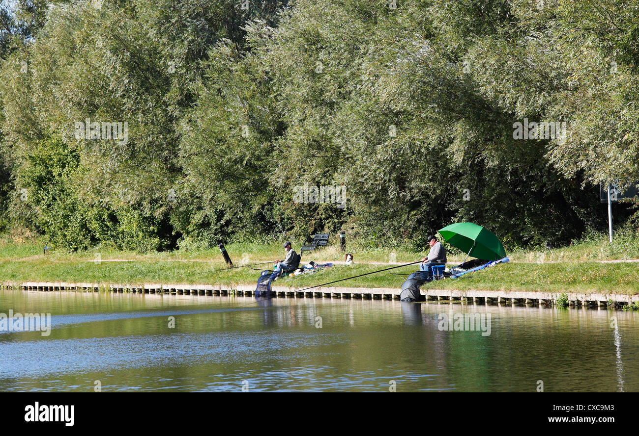 Two fishermen on banks of river Cam Milton Cambridgeshire Stock Photo