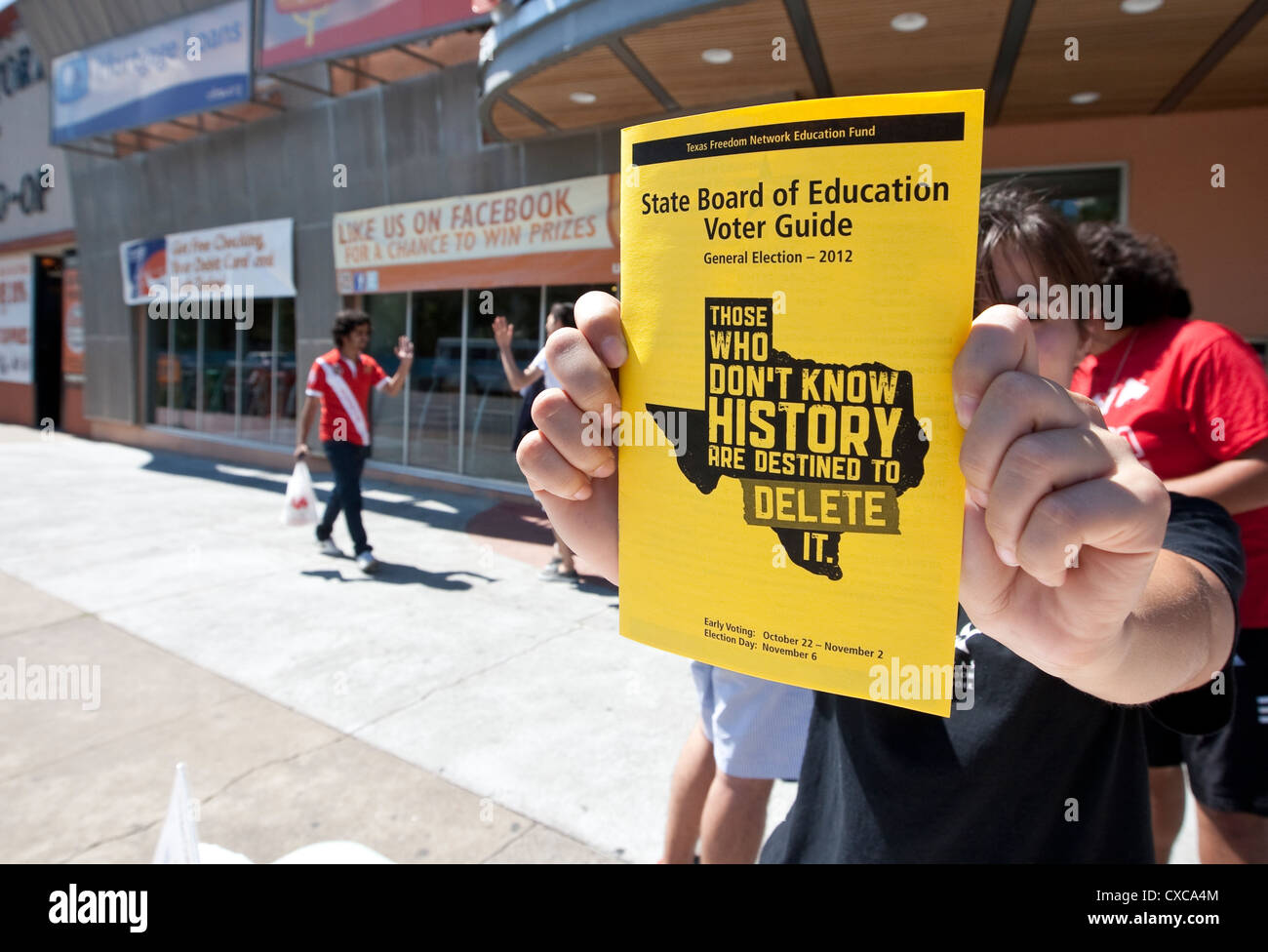 Female student volunteer holds up Texas State Board of Education Voter guide flyer during voter registration guide in Texas Stock Photo
