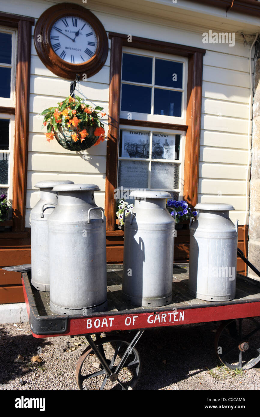 Milk churns on a cart at the restored Boat of Garten Steam Railway station in the Scottish Highlands Stock Photo