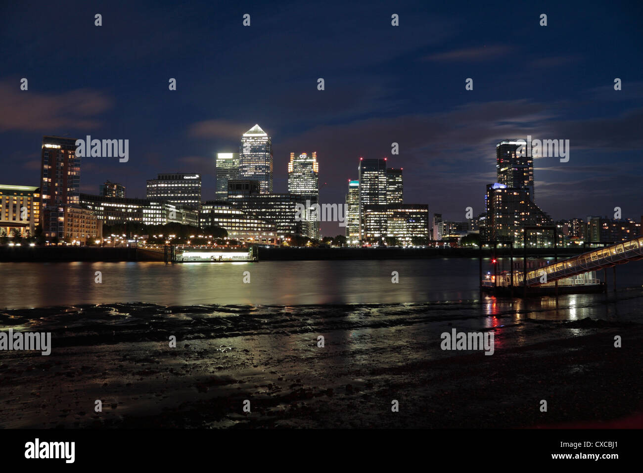 Skyscrappers offices lit at night reflecting off water hires stock