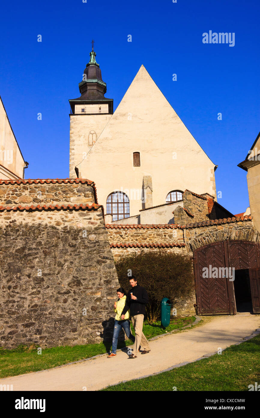 A couple walking by the church of St James the Elderly in Telch, Czech Republic Stock Photo