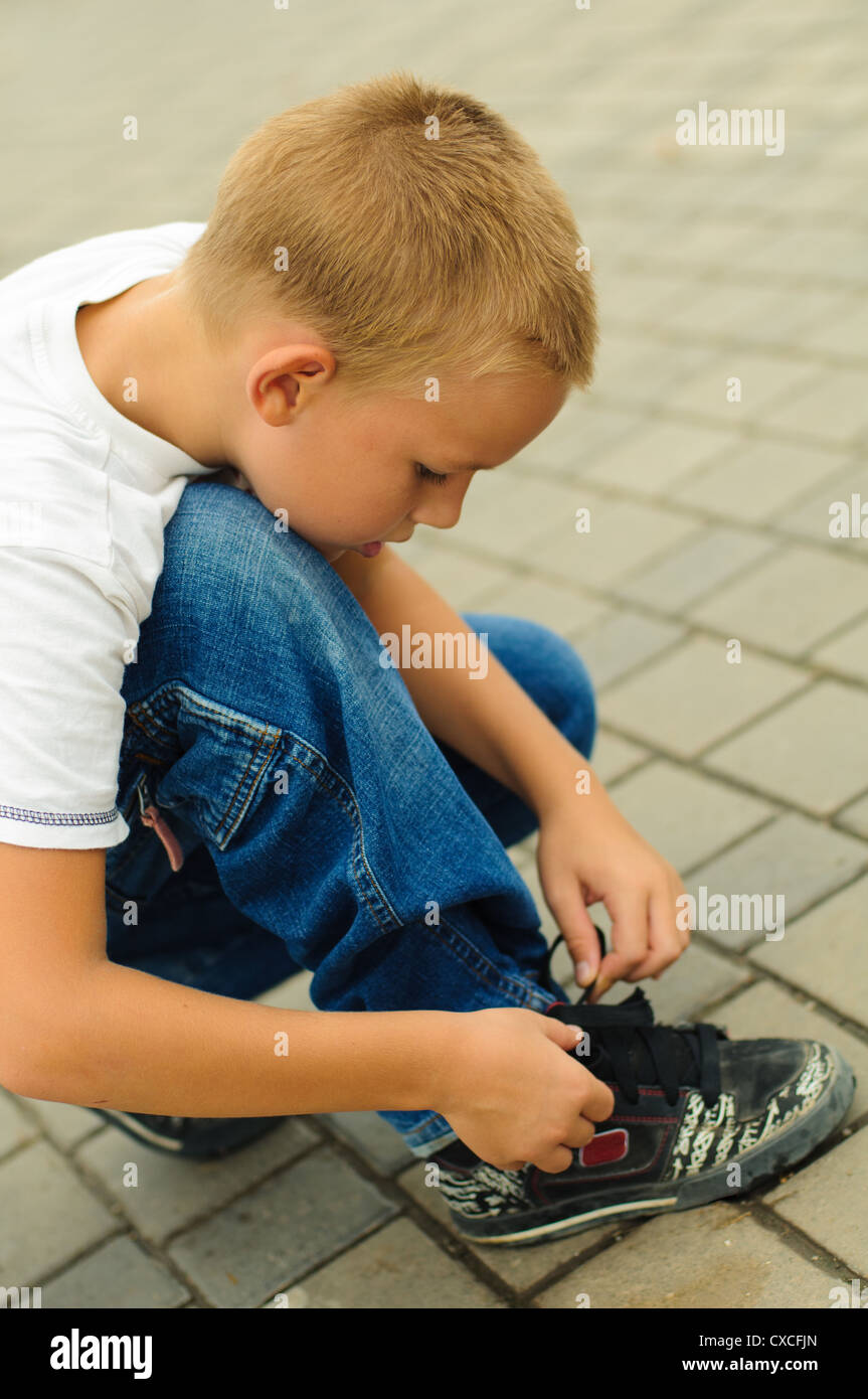 Boy tying the laces on his sneakers Stock Photo Alamy