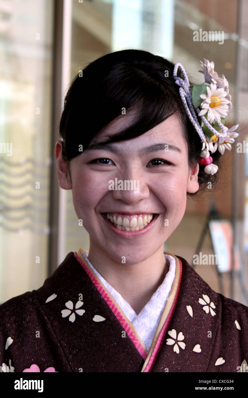 Head and shoulders portrait of young, smiling Japanese woman in