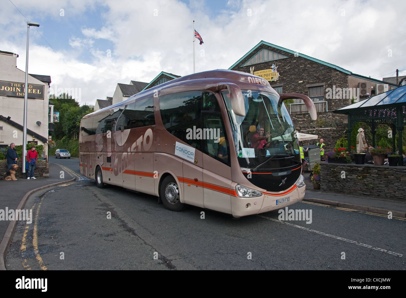 Spanish tourist coach passing Beatrix Potter World, Bowness Stock Photo