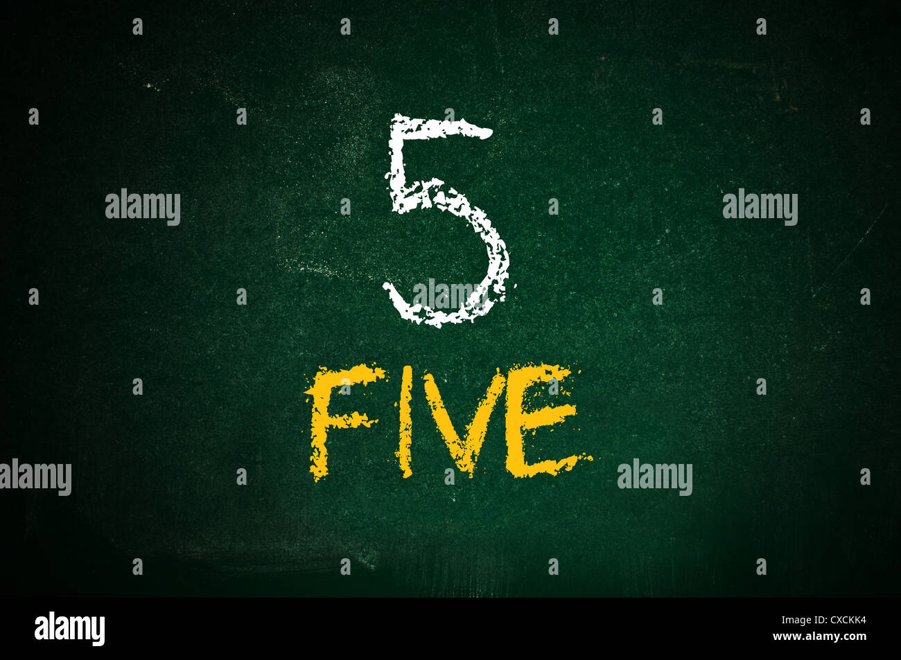 Number five, handwritten number five with a chalk on a green chalkboard. Stock Photo