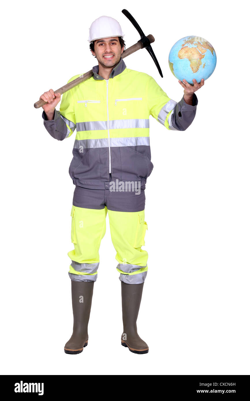 Labourer holding a globe and a pickaxe Stock Photo