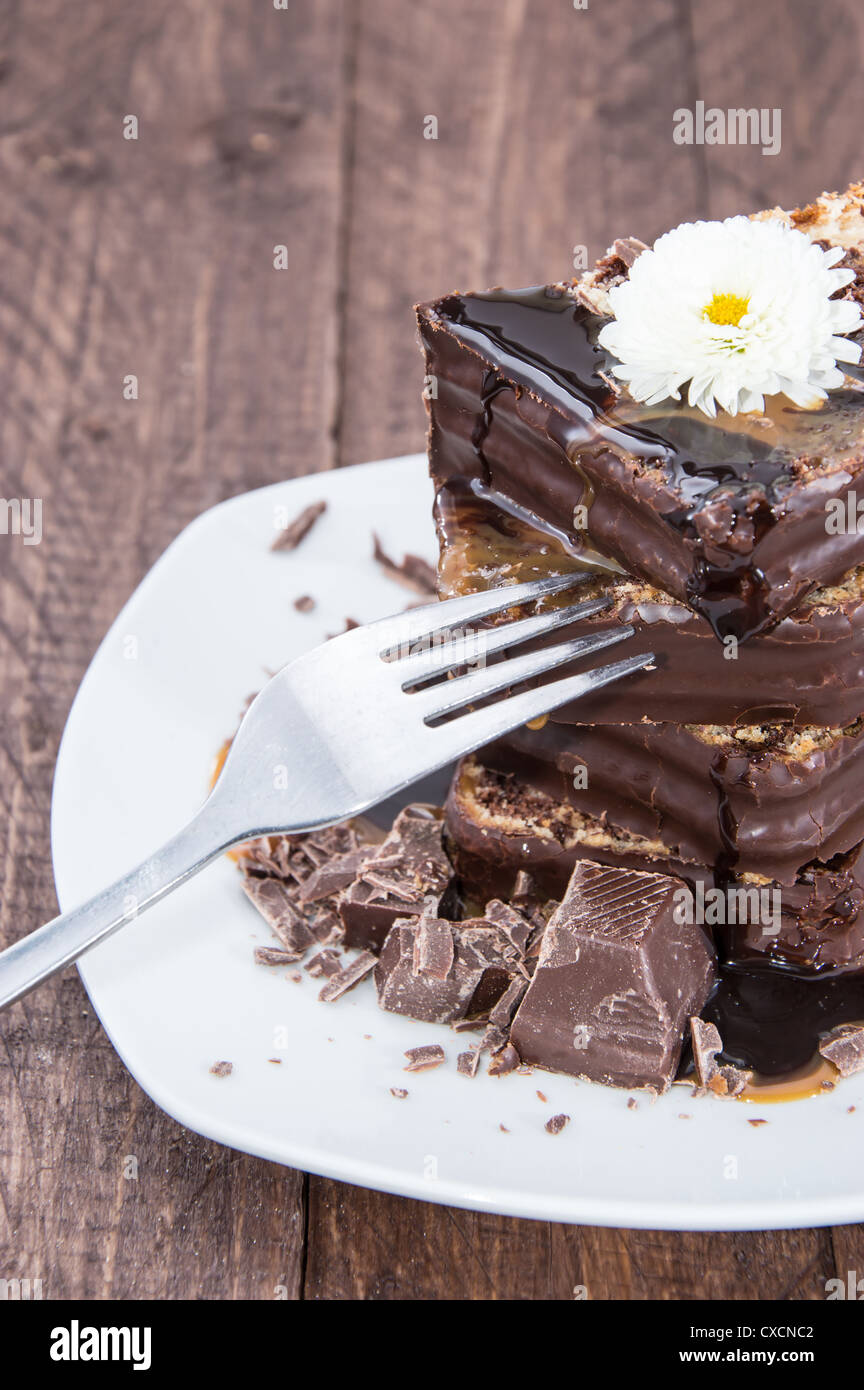 Stacked Chocolate Cake with sauces on wooden background Stock Photo