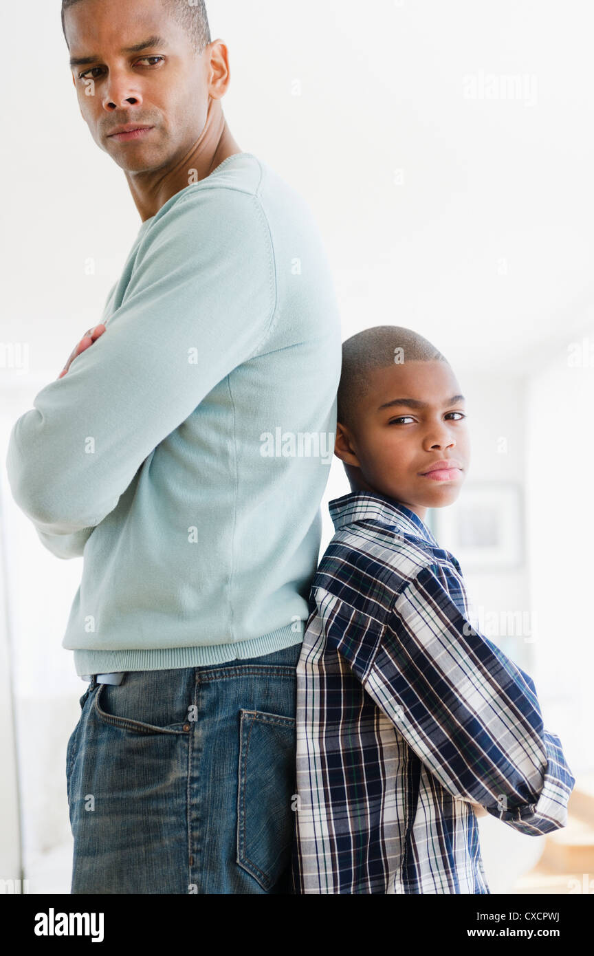 Stubborn father and son standing back to back Stock Photo Alamy