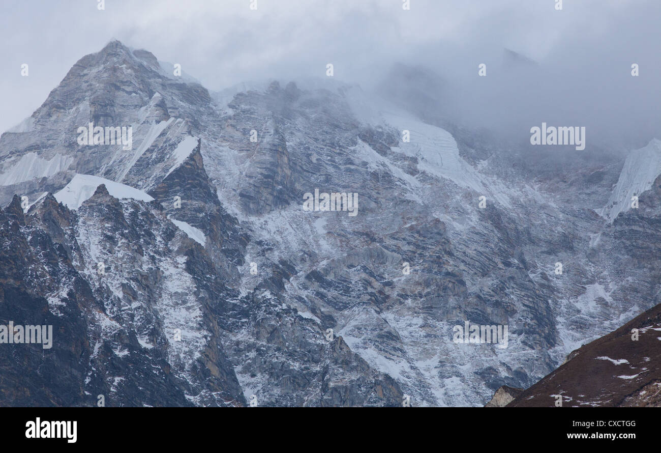 Cloud sweeping over a snowcapped mountain covered with snow and ice along the Langtang Valley, Nepal Stock Photo