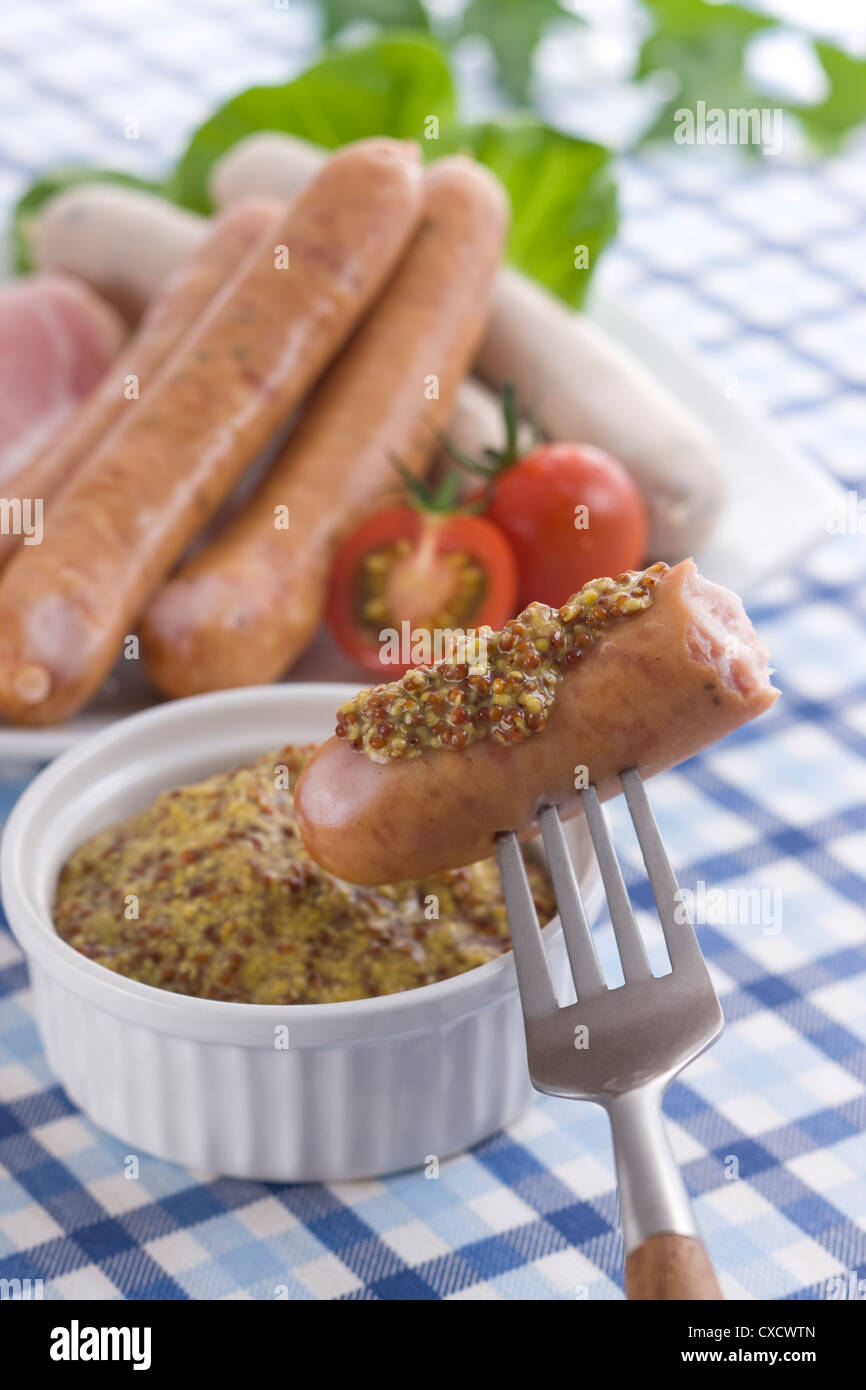 Putting Wholegrain Mustard on Sausage Stock Photo Alamy