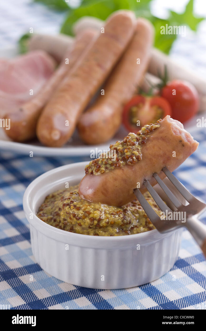 Putting Wholegrain Mustard on Sausage Stock Photo Alamy