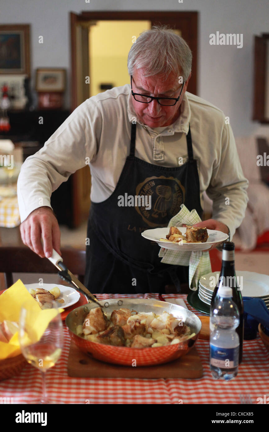 A northern Italian at home serving traditional food (stockfish with onion and potatoes). Friuli Venezia Giulia, Italy. Stock Photo