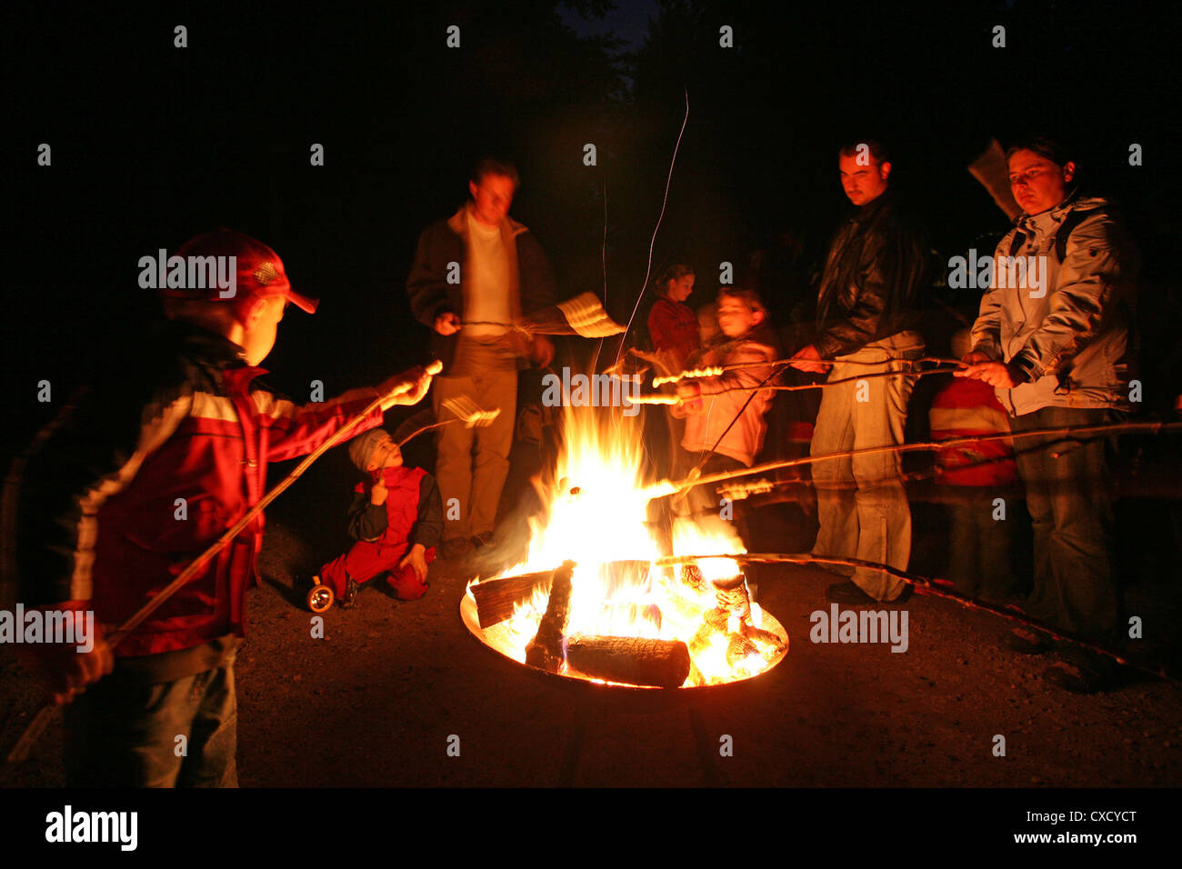 Resplendent village, people grilling sausages over an open fire Stock Photo