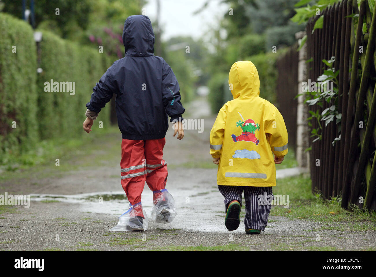 Berlin children in raincoats walk along a path Stock Photo