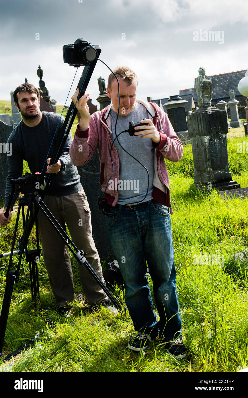 A small film crew making a short film using Canon DSLR cameras on location  in a cemetery in West Wales UK Stock Photo - Alamy