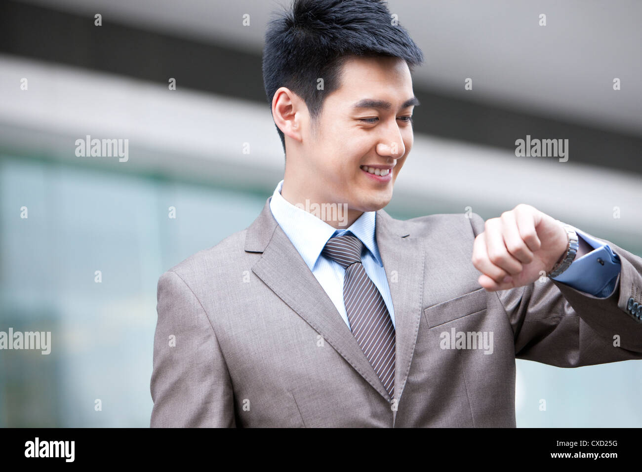 Young businessman checking time Stock Photo - Alamy