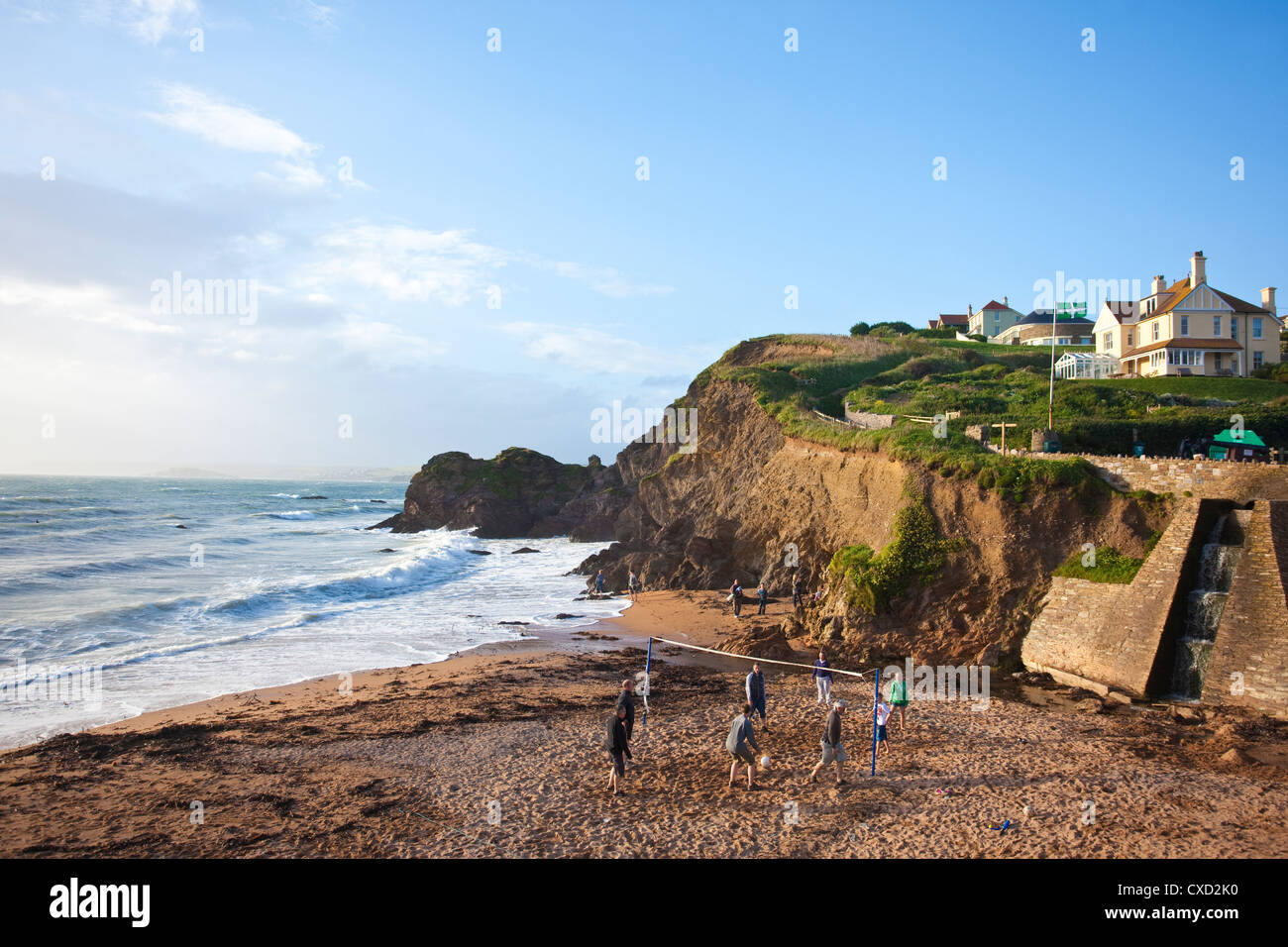 Tourists play volleyball in the evening light on Shippen beach at Outer Hope, Hope Cove, South Hams, Devon, England, UK Stock Photo