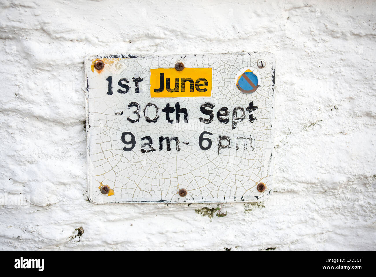 A parking restriction sign in Portloe Cornwall, crazed from years of use with repairs to the word June  - a 'distressed' look Stock Photo
