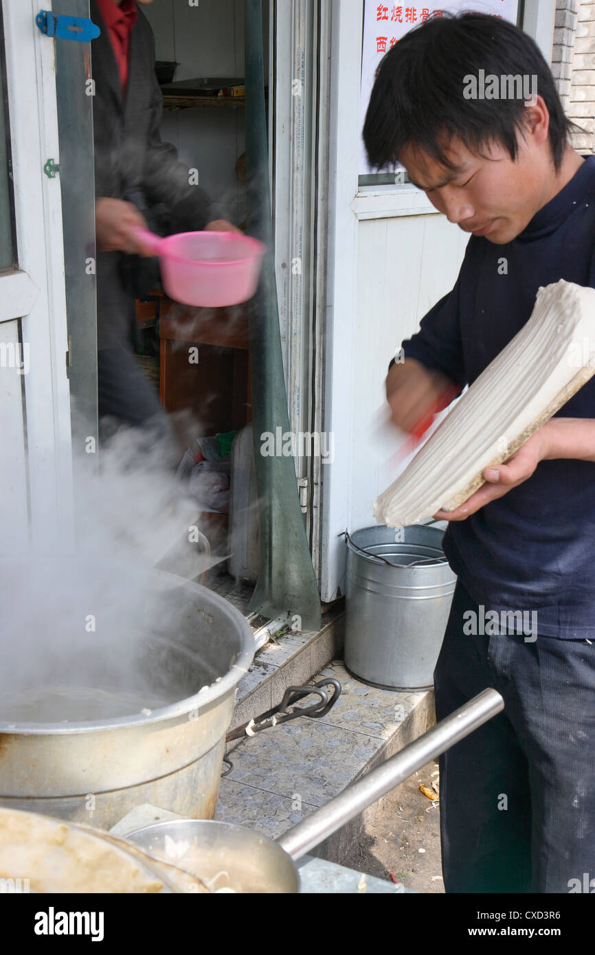 Beijing man planed noodles in boiling water Stock Photo