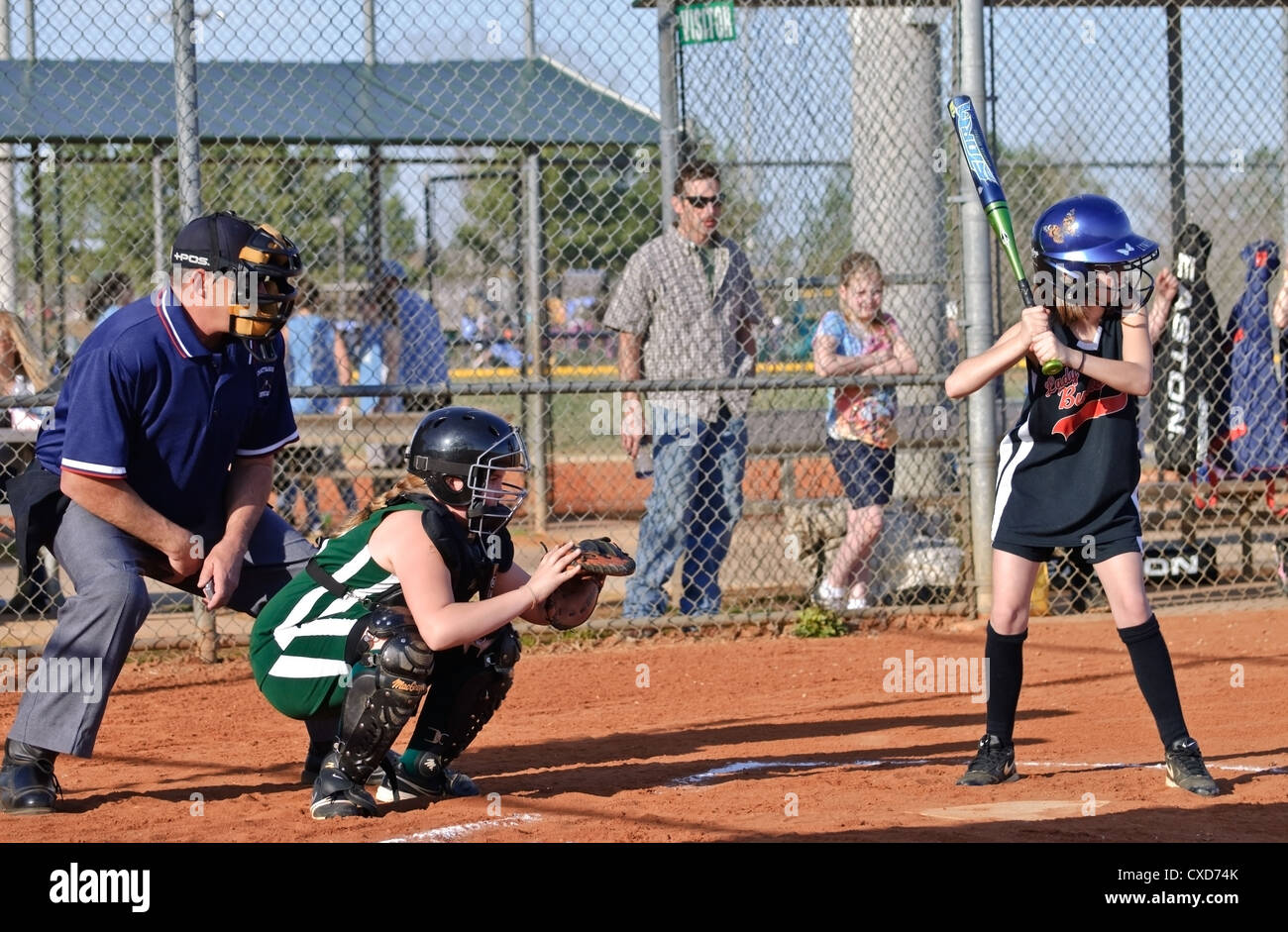 Action at home plate during a softball game showing the batter, catcher, and umpire. Stock Photo