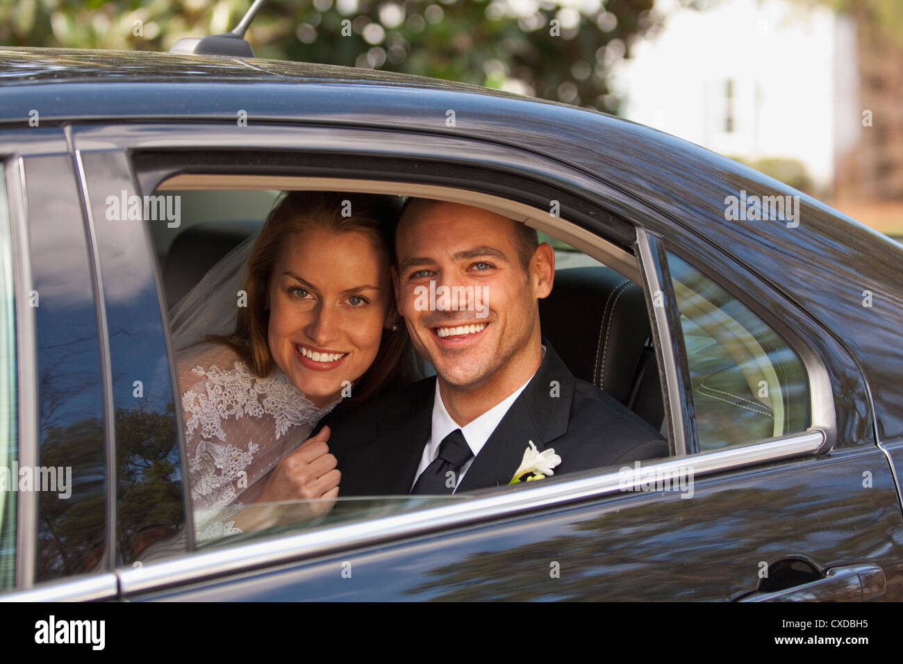 Caucasian bride and groom in back seat of car Stock Photo - Alamy