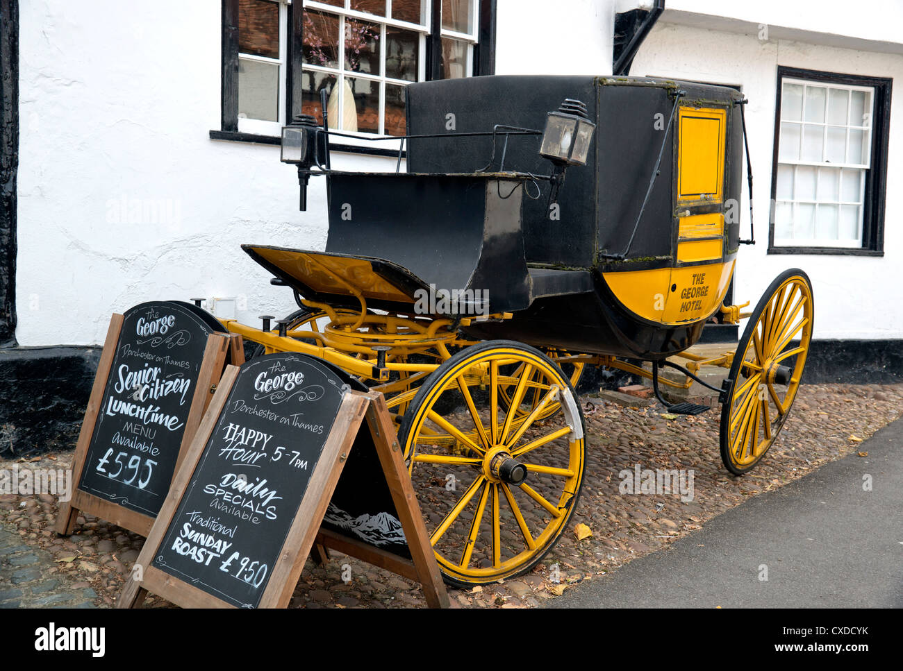 Old Carriage in front of the George Hotel in Dorchester (Oxfordshire) with an advertisement for food Stock Photo