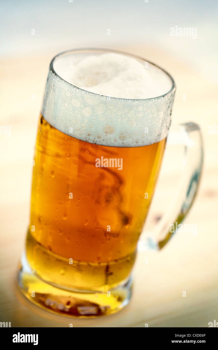 Single beer glass close-up on wooden table Stock Photo