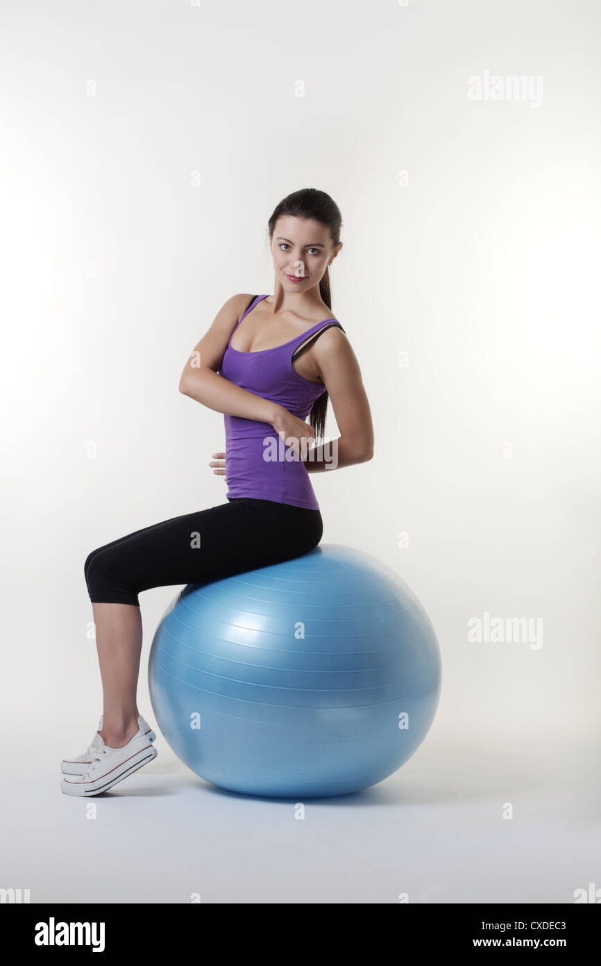 fit looking young woman doing stretching exercises on a gym ball Stock ...